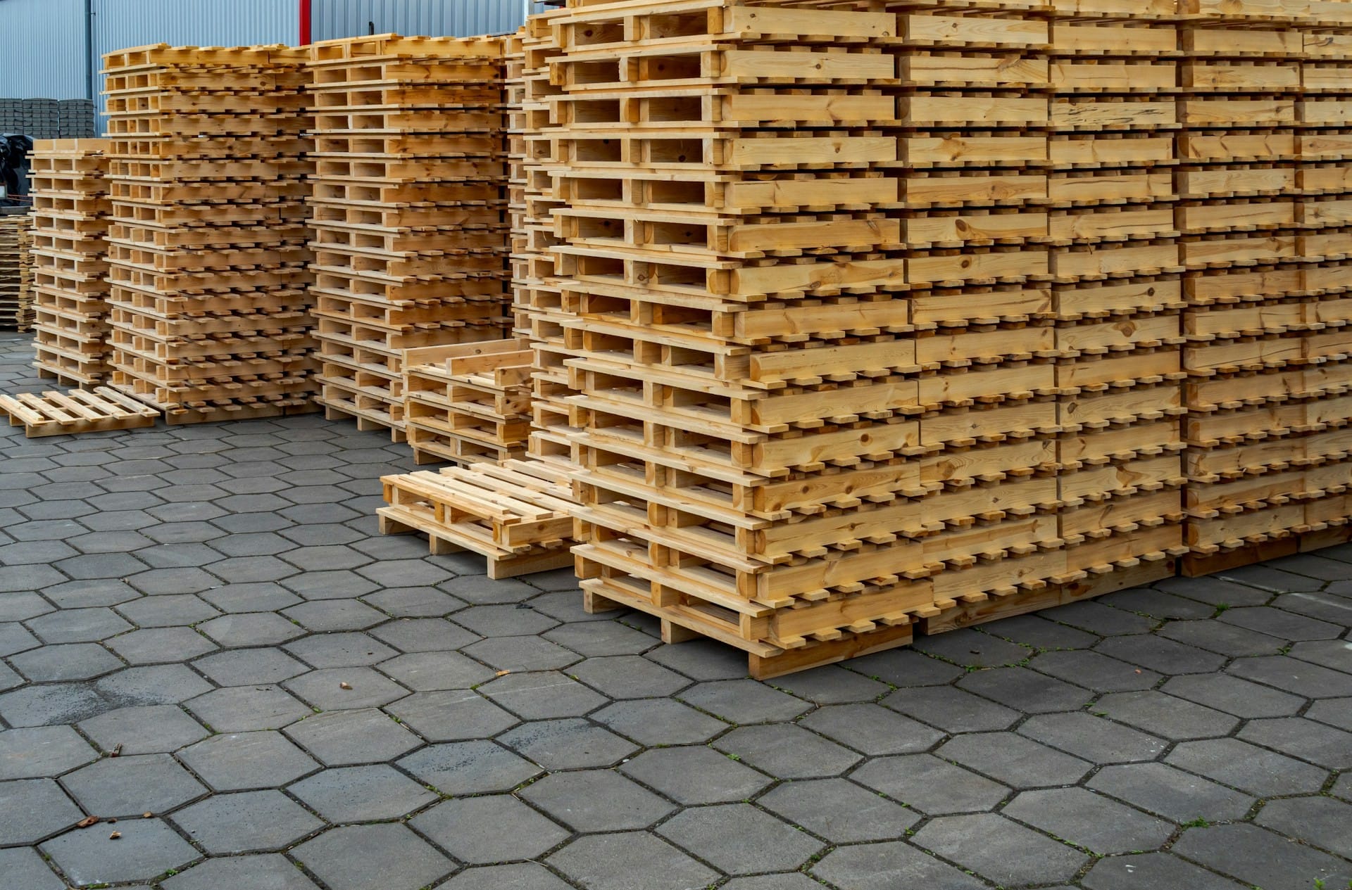 Stacked wooden pallets stored outdoors in a logistics yard for transport and storage use